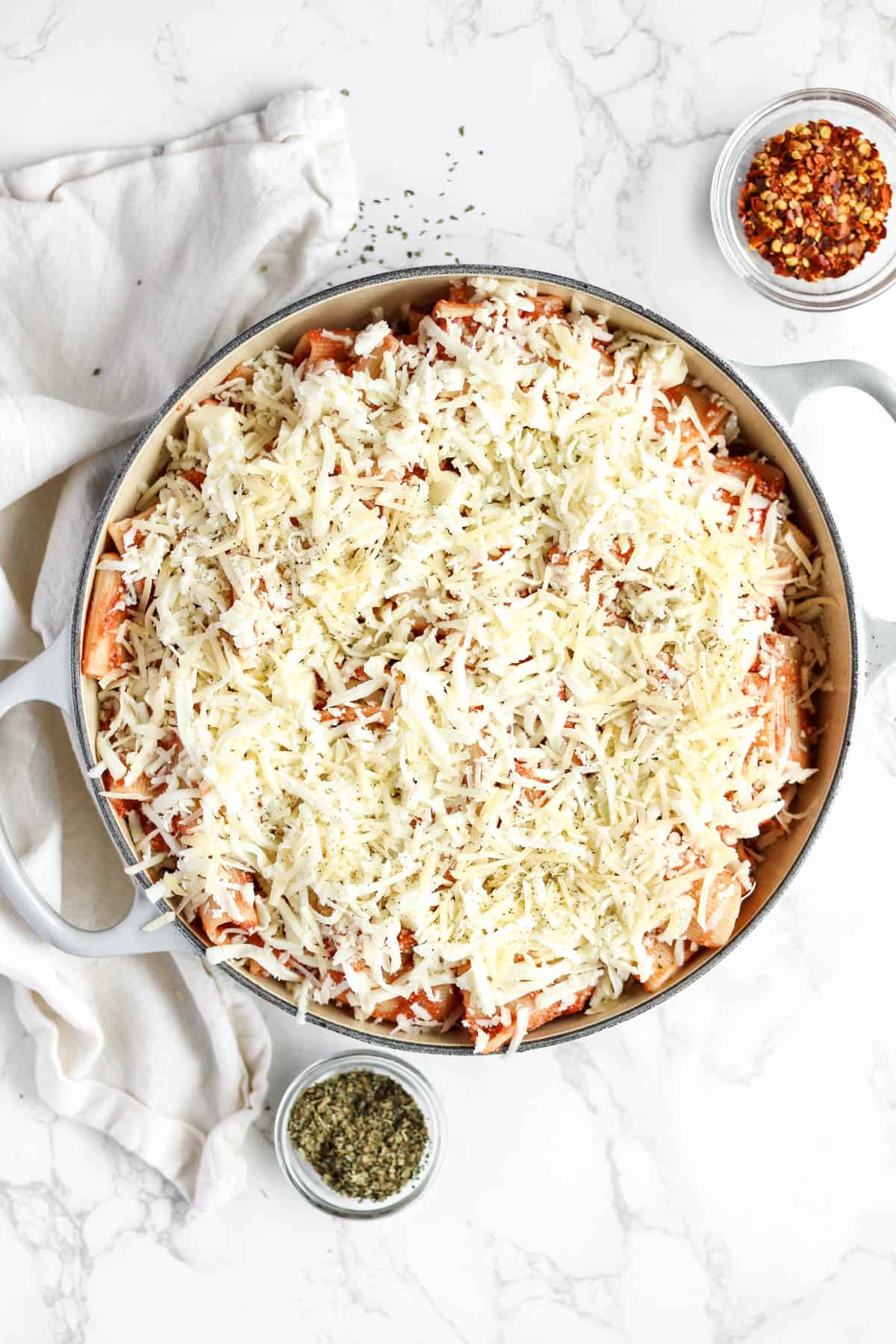 Pasta in sauce topped with shredded cheeses.