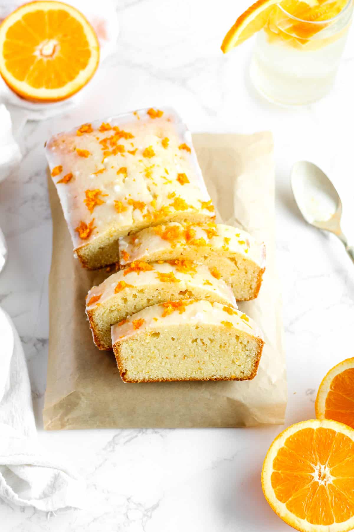 Sliced orange loaf cake with citrus glaze.