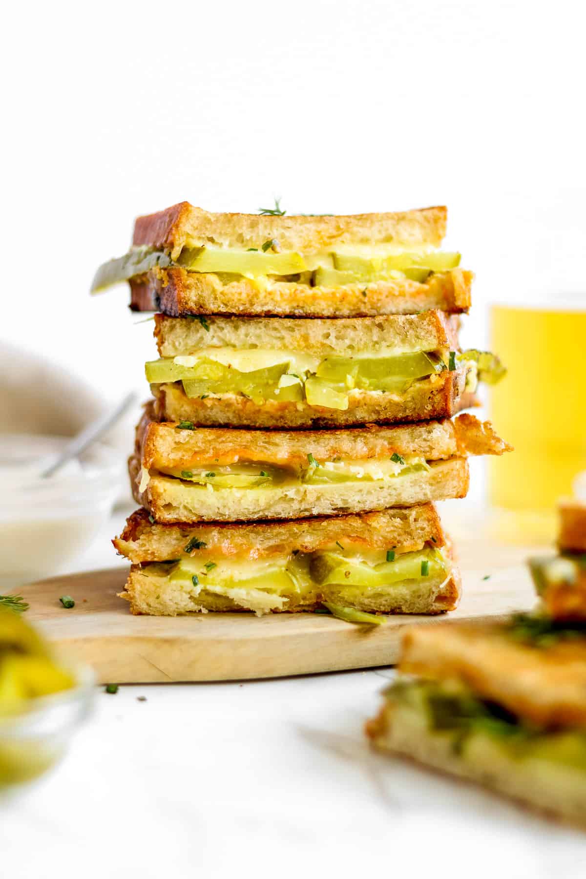 Stack of pickle and cheese grilled cheese sandwiches.