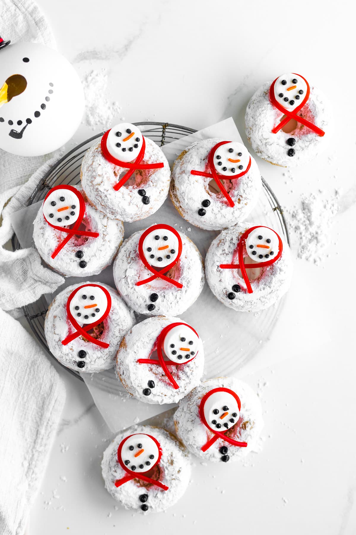 Decorated winter donuts on a wire rack.