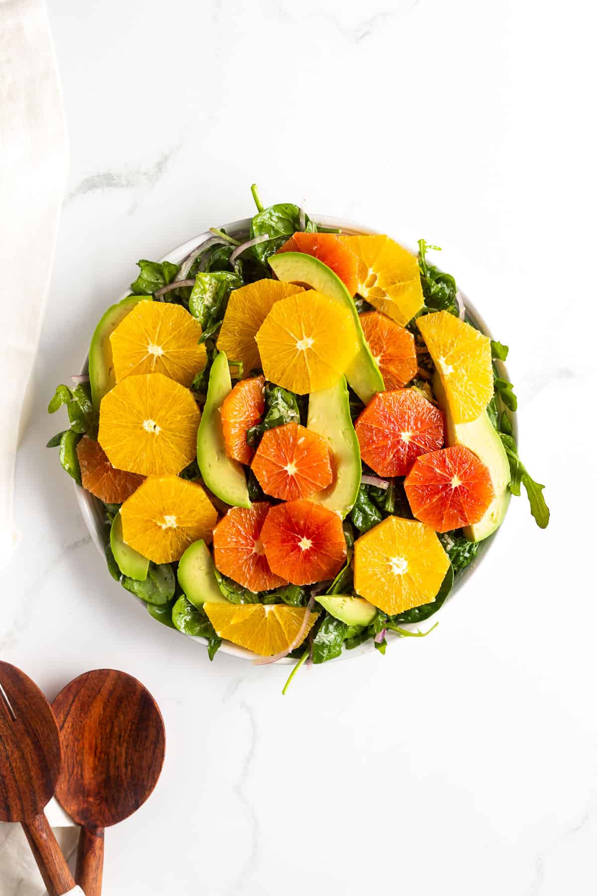 Oranges and avocado plated on salad greens.